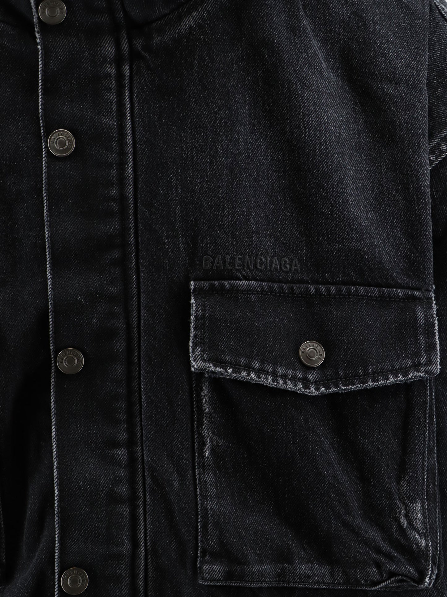 Black denim jacket with embroidered logo on the front